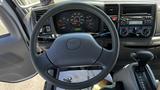 The interior dashboard of a 2006 Ford LCF 550 featuring a steering wheel multiple gauges and a control panel with audio and climate controls