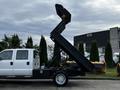 A 2015 Ford F-550 truck with a raised dump bed in a side profile view