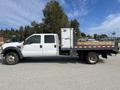 A 2010 Ford F-550 with a flatbed and a refrigerated box on the side parked on a roadway