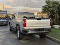 A silver 2023 Chevrolet Silverado 3500HD pickup truck is seen from the rear with prominent CHEVROLET branding on the tailgate and rugged tires