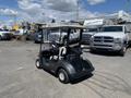 2019 Yamaha G29 E Electric G29 Golf Car with a black body and beige accents parked with several vehicles in the background