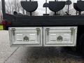 Two metal storage boxes with slatted vents mounted on the back of a black truck