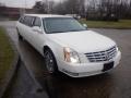 A white 2008 Cadillac Limousine with chrome wheels and distinctive front grille