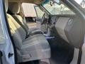 Interior view of a 2013 Ford Expedition showcasing front seats and dashboard with a minimalist design and light upholstery