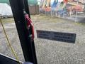 A door handle with a red lift mechanism labeled for emergency exit instructions in English and French on a 2017 Chevrolet Express van