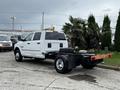 A white 2018 RAM 3500 truck with an empty bed and dual rear wheels parked in a lot