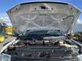 The hood of a 2019 Ford F-350 SD is open revealing the engine compartment with various components and machinery visible inside