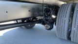 View of the rear axle and suspension system of a 2019 International 4300 with large tires and a blacked-out framework