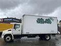 A 2008 Hino Conventional Cab truck with a large white cargo box featuring green graffiti on the side