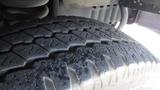 Close-up of a 2011 Ford Econoline tire showing detailed tread pattern with visible grooves and wear indicators