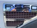 Close-up of a 2010 Ford F-550 badge showing "F-550 XLT Super Duty V8 Power Stroke" with a distinctive grille design