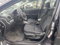 Interior of a 2014 Subaru Impreza showing front seats dashboard and gear console with black fabric upholstery and a simple layout