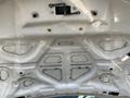 The underside of a 2019 Ford F-350 SD hood featuring a smooth white finish with various mounting points and cutouts