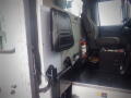 A 2008 International 7400 truck interior showing the driver's seat and control panel with a fire extinguisher and storage compartment visible