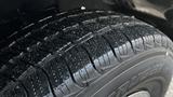 Close-up of a wet tire tread from a 2005 Chevrolet Express showcasing deep grooves and patterns designed for traction