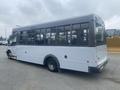 A 2017 Chevrolet Express bus with large windows and a streamlined body design showing a white and gray color scheme