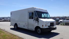 A white 2006 Ford Econoline cargo van with a boxy shape and large front windows parked in a lot