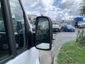 A 2017 Mercedes-Benz Sprinter with a focus on the side mirror reflecting the surroundings