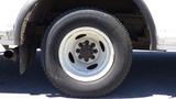 Close-up of a wheel from a 2006 Ford Econoline with a white rim and a black tire featuring visible tread patterns