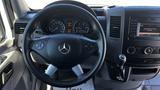 The interior of a 2016 Mercedes-Benz Sprinter featuring a steering wheel with control buttons and a dashboard display showing speed and other metrics