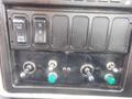 Control panel of a 2009 International 7400 featuring switches for engine brake and multiple toggle switches with green knobs