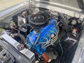 Engine compartment of a 1966 Ford Mustang featuring a blue engine block and a black air cleaner with various hoses and components visible