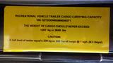 Yellow label detailing the cargo carrying capacity of a 2021 Forest River 312BH East To West Della Terra recreational vehicle trailer