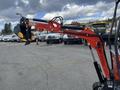 A red and black 2024 AGT Mini Excavator with a distinctive arm and bucket attachment positioned prominently in the foreground