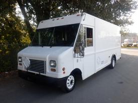 A white 2006 Ford Econoline delivery truck with a flat front and large windshield featuring multiple side windows and a small cargo area in the back