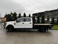 A white 2020 Ford F-350 Super Duty truck with a flatbed and black wheels is positioned in profile view