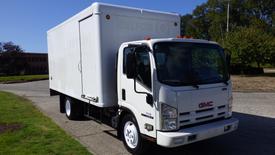 White 2009 GMC W5500-HD box truck with a large cargo area and orange clearance lights on the roof