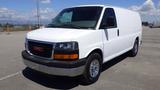 A white 2012 GMC Savana van with a black grille and chrome bumper parked at a distance with no visible cargo in the back