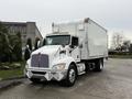 A 2017 Kenworth T370 truck with a white box cargo trailer and chrome accents parked with its headlights on