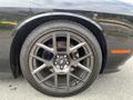 A close-up of a black 2017 Dodge Challenger wheel showcasing a sporty alloy rim with multiple spokes and a low-profile tire