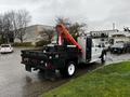 A 2014 Ford F-550 with a flatbed and a crane mounted on the back