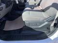 The interior of a 2019 Ford F-350 SD featuring a gray fabric seat and a console with controls and a paper mat on the floor