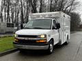 A 2016 Chevrolet Express van with a white exterior equipped for emergency services featuring a boxy shape and multiple lights on top