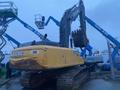 A yellow 2014 John Deere 350G excavator with a large bucket attachment and tracks visible in the foreground