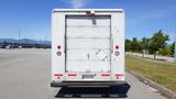 A white 2006 Ford Econoline van seen from the rear with a large cargo door and a small diamond-shaped window on the left side