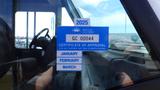 A blue certificate of approval sticker affixed to the windshield of a 2011 Ford Econoline with the year 2025 and monthly options listed