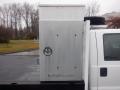 A metal storage box mounted on the side of a white 2009 Ford F-450 SD truck