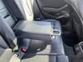 A 2016 Audi A3 rear seat with a black leather center armrest console and cup holders