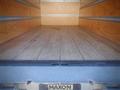 A 2013 Mitsubishi Fuso FE 160 with an empty wooden cargo area showcasing the wooden floor and metal loading ramp