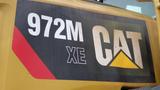 Close-up of a 2019 Caterpillar 972M XE logo featuring the model number in bold with the CAT brand emblem and a red and black design