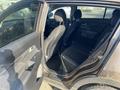 A 2012 Kia Sportage with an open back door showing the rear seat area and interior details