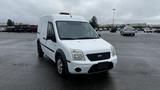 A white 2012 Ford Transit van with an orange rooftop light parked in a lot facing the viewer