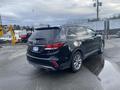 A black 2017 Hyundai Santa Fe SUV viewed from the rear, showcasing its sleek design and alloy wheels