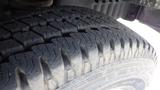 A close-up of a tire with a deep tread pattern on a 2011 Ford Econoline