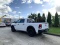 White 2021 RAM 1500 pickup truck with black wheels parked with a view of the back and side details