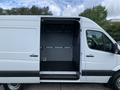 A white 2017 Mercedes-Benz Sprinter van with an open side door revealing the interior cargo space